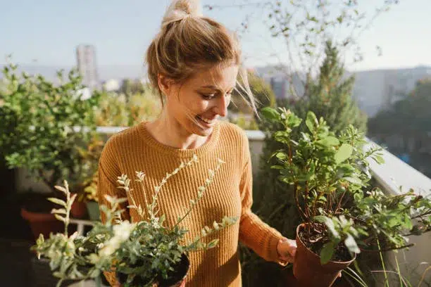 Chica con plantas en su huerto urbano